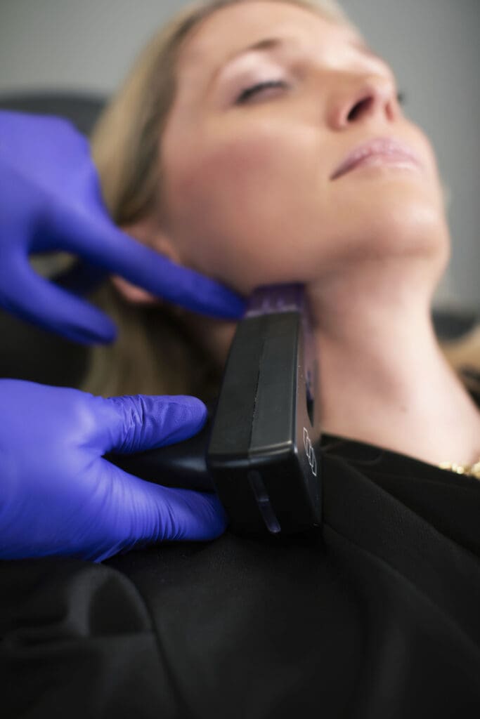 Woman receiving Morpheus8 radiofrequency microneedling treatment to jawline for non-surgical skin tightening.
